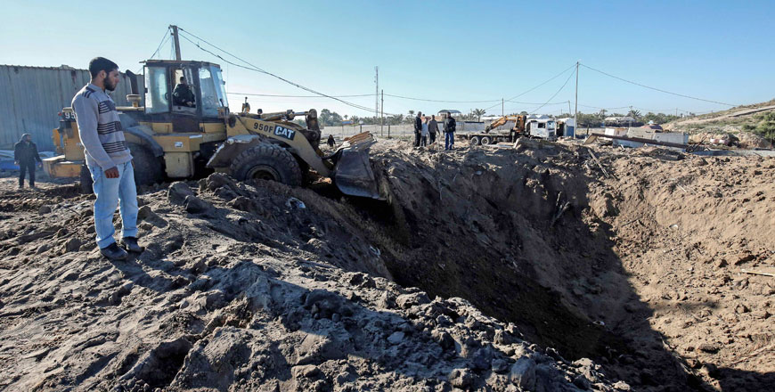 Palestinian men clear the rubble at the site of an Israeli air strike near a seaport under construction, near Khan Younis in the southern Gaza Strip, on Saturday (AFP photo)