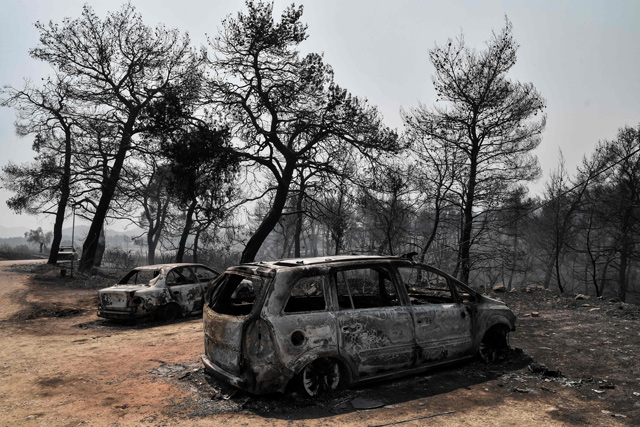 A photo takenn on Wednesday shows the wreckages of burned cars and burned trees after a wildfire near the village of Makrymalli, on the Greek Evia Island also known as Euboea (AFP photo)