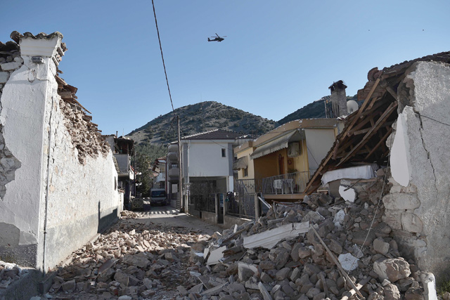 An army helicopter flies over collapsed buildings in the village of Damasi, near the town of Tyrnavos, after a strong 6,3-magnitude earthquake hit the Greek central region of Thessaly, on Wednesday (AFP photo)