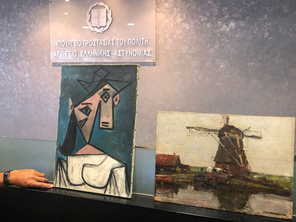 This handout photo taken and released by the Greek culture ministry on Tuesday shows a recovered painting of Picasso titled ‘Head of a Woman’ flanked by a painting by Dutch painter Piet Mondrian, in Athens (AFP photo)