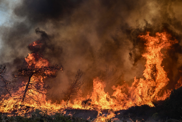 Wildfires burn the forests near the village of Vati, just north of the coastal town of Gennadi, in the southern part of the Greek island of Rhodes, on Tuesday (AFP photo)