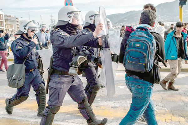 Migrants and refugees scuffle with riot police on the Greek Aegean island of Lesbos on Tuesday (AFP photo)