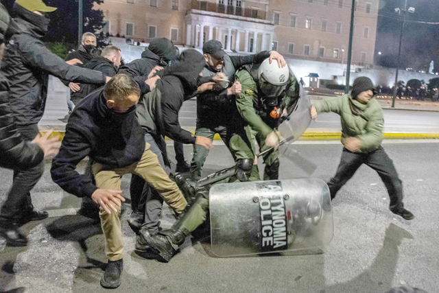 Protesters clash with Greek riot police forces in front of the Greek parliament in Athens on Friday, as parallel demonstrations take place, following the deadly accident near the city of Larissa, where 57 people, mainly students lost their lives (AFP photo)
