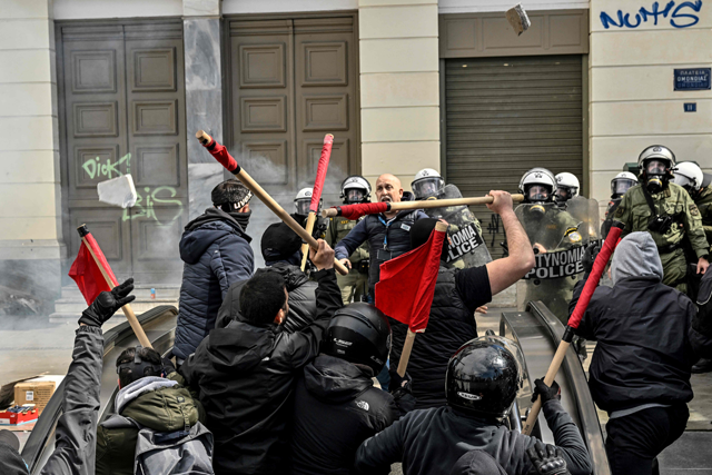 Protesters clash with riot police at the entrance of a metro station during a demonstration in Athens, on Sunday (AFP photo)