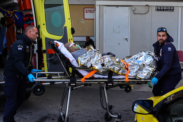 Medical staffs carry on a stretcher a survivor from the Comoros-flagged cargo ship that has sunk off the island of Lesbos, at a hospital on Lesbos Island on Sunday (AFP photo)