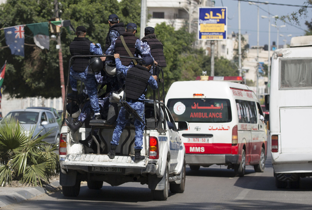 Hamas police secure the area as an ambulance reportedly carrying the bodies of men accused of collaborating with Israel leaves the main police building in Gaza City on Thursday (AFP photo)