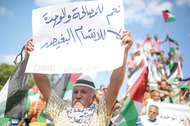 Demonstrators hold placards as they march towards Al Saraya Square during a protest against the blockade of Gaza Strip imposed by Israel for the past eleven years, in Gaza City on Sunday (Anadolu Agency photo)