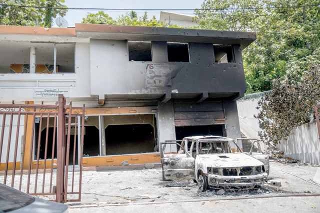 A charred car and building are photographed near the Petionville police station after incidents, where suspects of being involved in the assassination of president Jovenel Moise are being held, in Petionville, Haiti, on Friday (AFP photo)