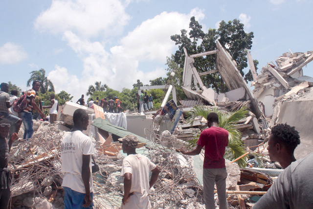 People search through the rubble of what used to be the Manguier Hotel after the earthquake hit on Saturday in Les Cayes, southwest Haiti (AFP photo)