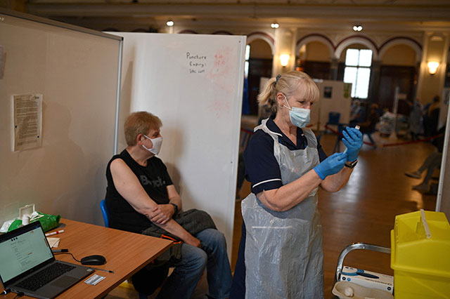 A health worker prepares a dose of the AstraZeneca/Oxford Covid-19 vaccine at a temporary vaccine centre set up at City Hall in Hull, northeast England, on Friday (AFP photo)