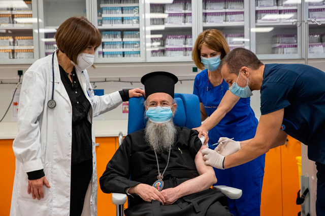 Metropolitan Hierotheos of Nafpaktos and Agios Vlasios receives a dose of the Pfizer-BioNTech COVID-19 vaccine at the Evangelismos Hospital in Athens on Sunday (AFP photo)