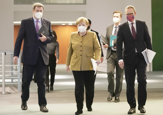German Chancellor Angela Merkel (second left), wearing a face mask together with Bavaria's State Premier Markus Soeder (left), Berlin's Mayor Michael Mueller (right) and government spokesman Steffen Seibert,  arrives to address a press conference following talks via video conference with Germany's state premiers on the extension of the current partial lockdown, at the Chancellery in Berlin on Tuesday (AFP photo)