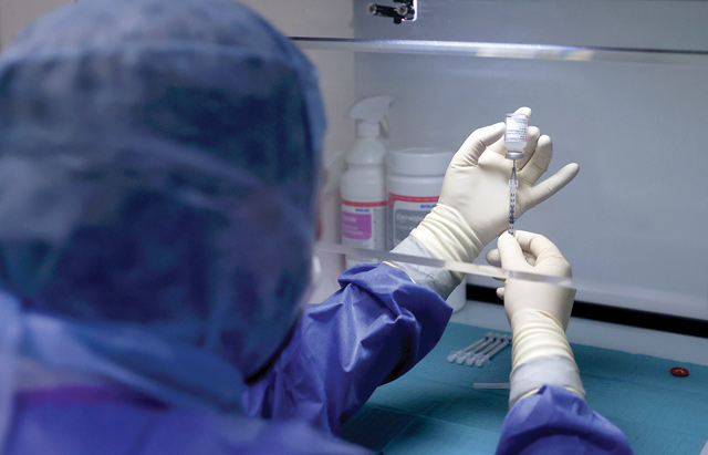 Pharmaceutical technician Christoph Apel fills a syringe with the Moderna COVID-19 vaccine at the corona vaccination centre at the University Hospital in Magdeburg, eastern Germany, on January 22 (AFP photo)