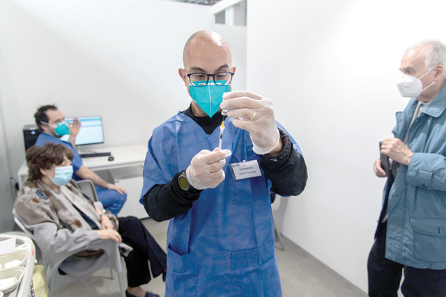 A medical worker fills a syringe with a dose of a Comirnaty Pfizer-BioNTech COVID-19 coronavirus vaccine at a new vaccination hub in Lingotto Fiere Torino Pavilion in Turin, on Wednesday (AFP photo)