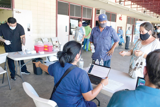 People check in for their COVID-19 vaccine at a mobile clinic on Friday in an East Los Angeles neighbourhood which has shown lower vaccination rates especially among the young  (AFP photo)