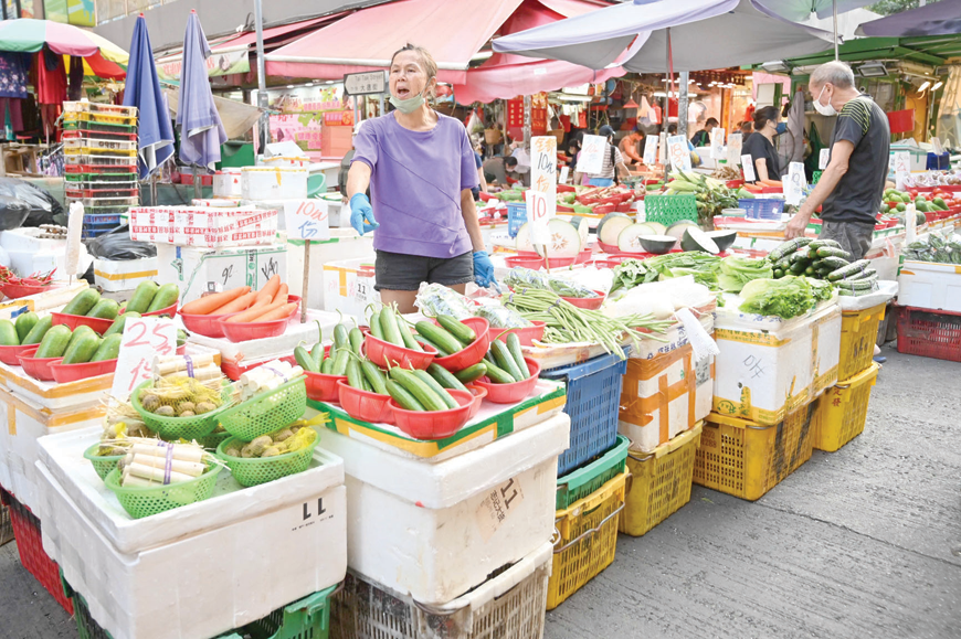 People shop for fruit and vegetables in a market in Hong Kong, on Sunday (AFP photo)