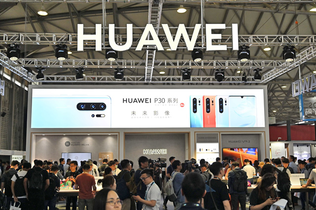 People gather at a Huawei stand during the Consumer Electronics Show, CES Asia 2019, in Shanghai, on Tuesday (AFP photo)