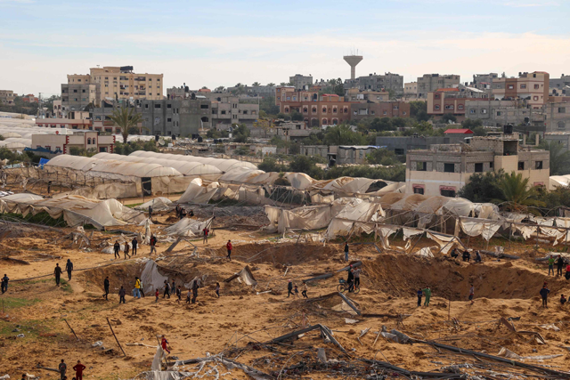 People stand around craters caused by Israeli bombardment in Rafah on the southern Gaza Strip on Monday (AFP photo)