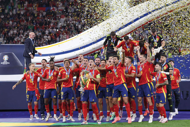 Spain's forward #07 Alvaro Morata holds the trophy and celebrates with teammates after winning the UEFA Euro 2024 final football match between Spain and England at the Olympiastadion in Berlin on Sunday (AFP photo)