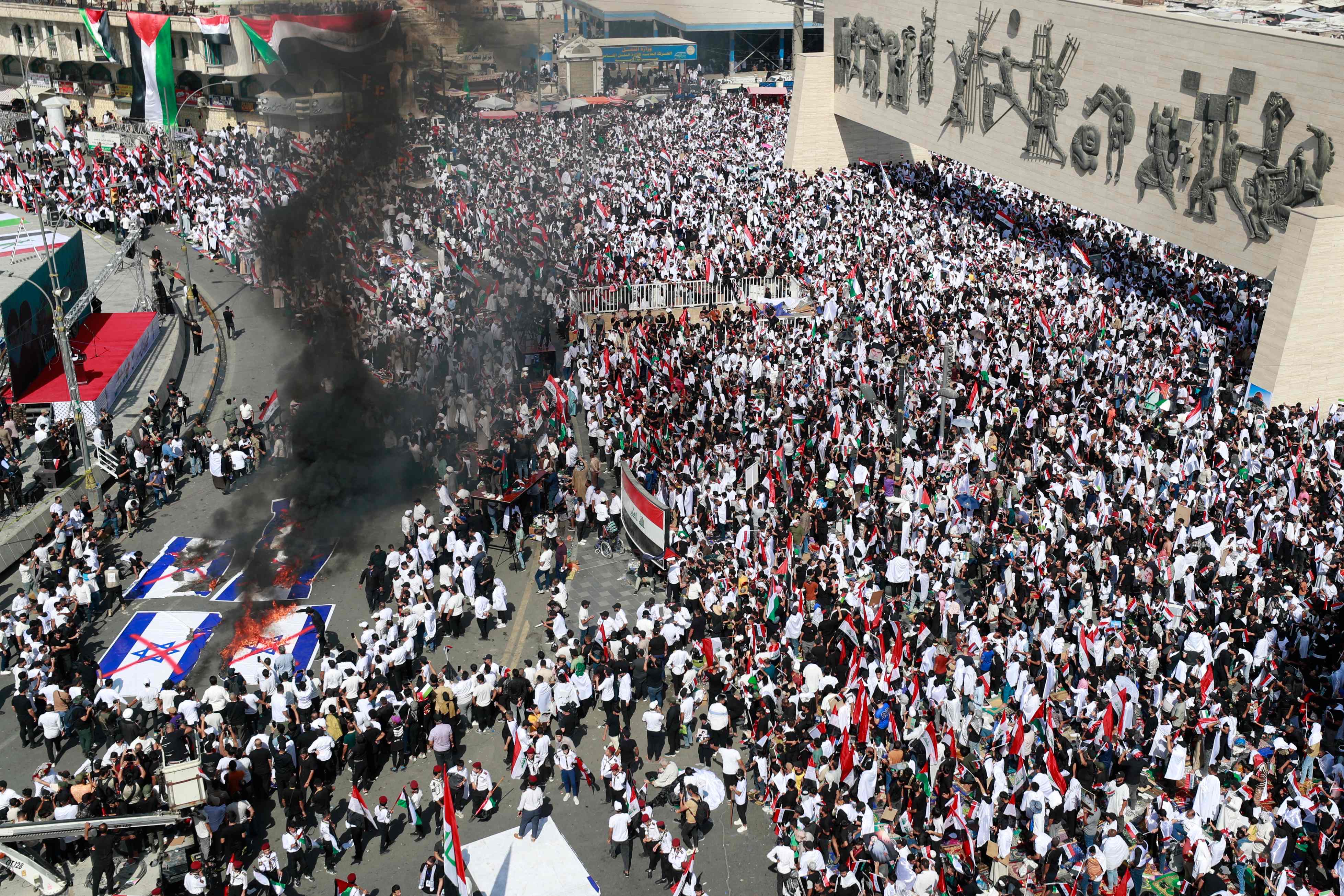 Protesters burn Israeli flags during a demonstration at Tahrir Square in Baghdad on Friday (AFP photo)