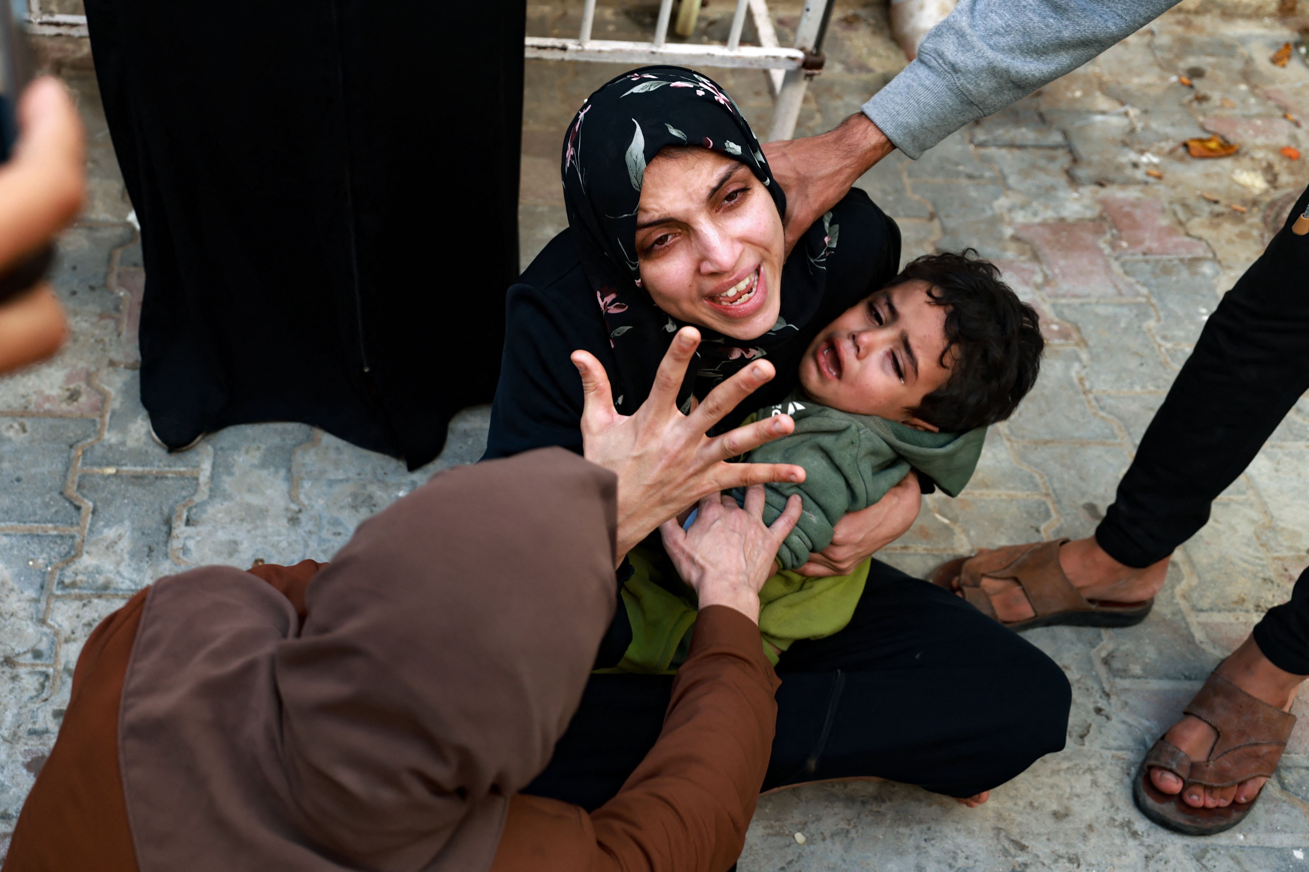 A woman holding a child mourns her baby girl killed in an Israeli strike in Rafah in the southern Gaza Strip, as she waits to receive the body for burial in the courtyard of the al-Najjar hospital on Friday, after battles resumed between Israel and the Hamas movement. A temporary truce between Israel and Hamas expired on Friday, with the Israeli army saying combat operations had resumed, accusing Hamas of violating the operational pause.   (AFP Photo by Mohammad Abed)