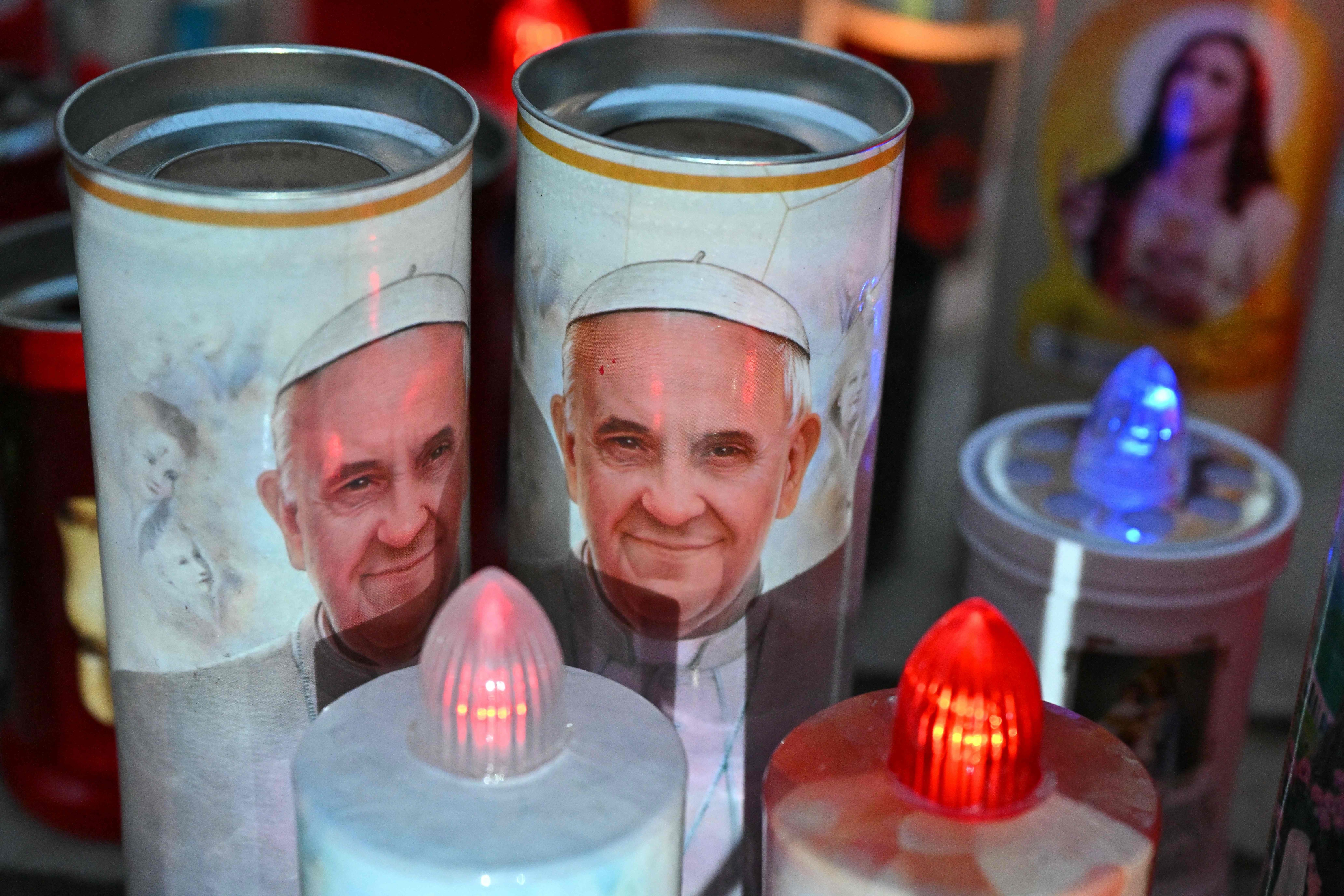 Candles with a image of Pope Francis are laid at the statue of John Paul II outside the Gemelli University Hospital where Pope Francis is hospitalized with pneumonia, in Rome on March 7, 2025 (AFP photo)
