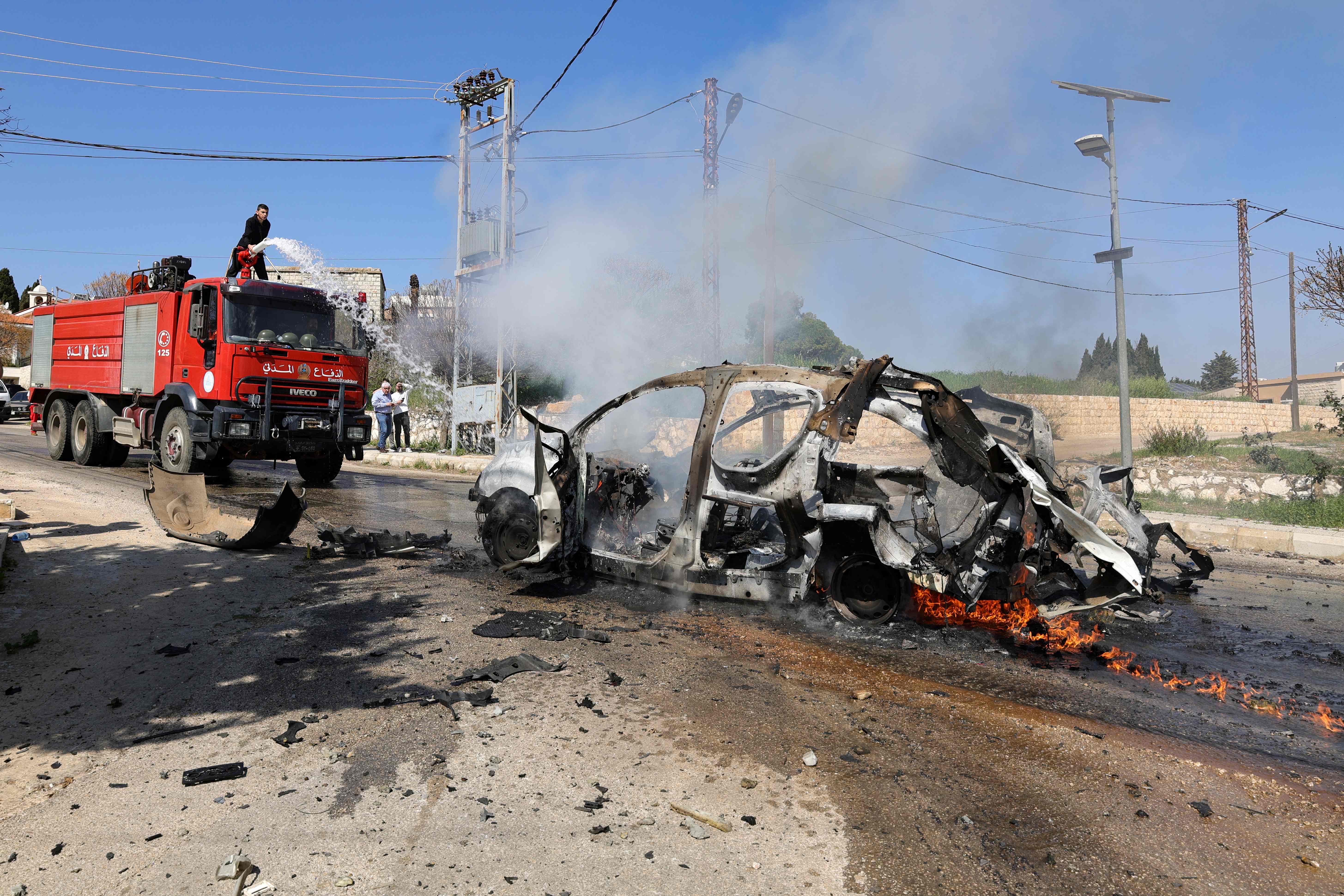 A firefighter douses the flames of a car hit by an Israeli strike in the southern Lebanese village of Burj al-Muluk on March 15, 2025, in which one person was reportedly killed (AFP photo)