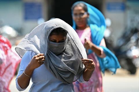 A pedestrian covers her face with a scarf while walking along a street on a hot summer day in Chennai on April 8, 2025 (AFP  photo)