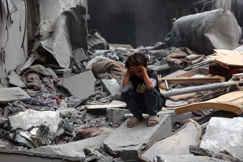 A Palestinian boy squats on the rubble of a building at the site of an Israeli strike on a residential area in Gaza City's Shujaiyya neighbourhood, on April 9, 2025 (AFP photo)