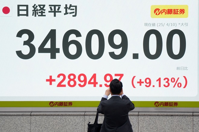 A man takes photos on an electronic board showing the closing numbers of the Nikkei Stock Average on the Tokyo Stock Exchange in Tokyo on April 10, 2025. Stocks in Asia rebounded strongly on April 10 after US President Donald Trump's stunning reversal on sweeping reciprocal tariffs  (AFP photo)
