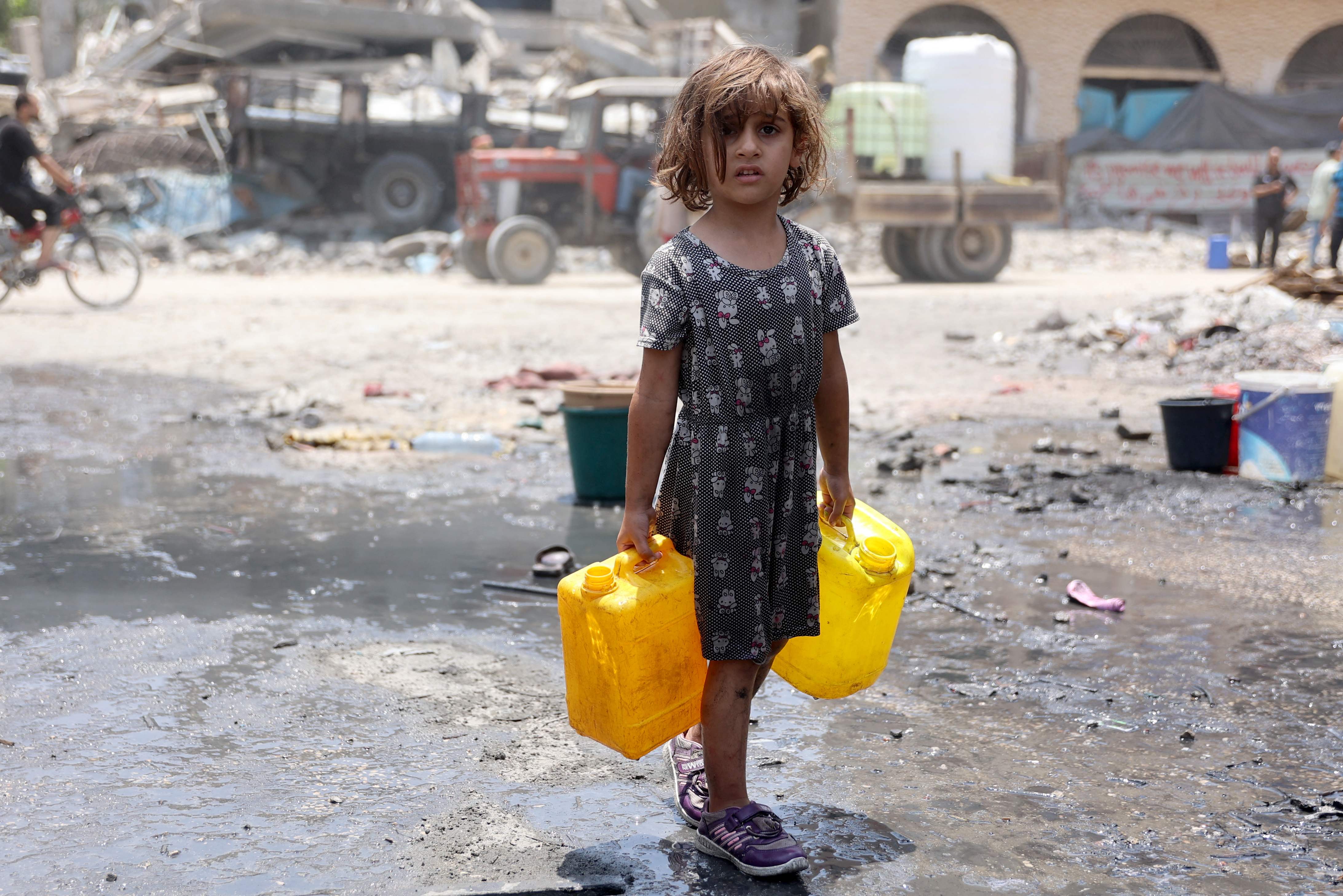 A Palestinian girl carries containers holding water in Jabalia refugee camp in the northern Gaza Strip on June 3, 2024, amid the ongoing Israeli war on the Strip ( AFP photo)