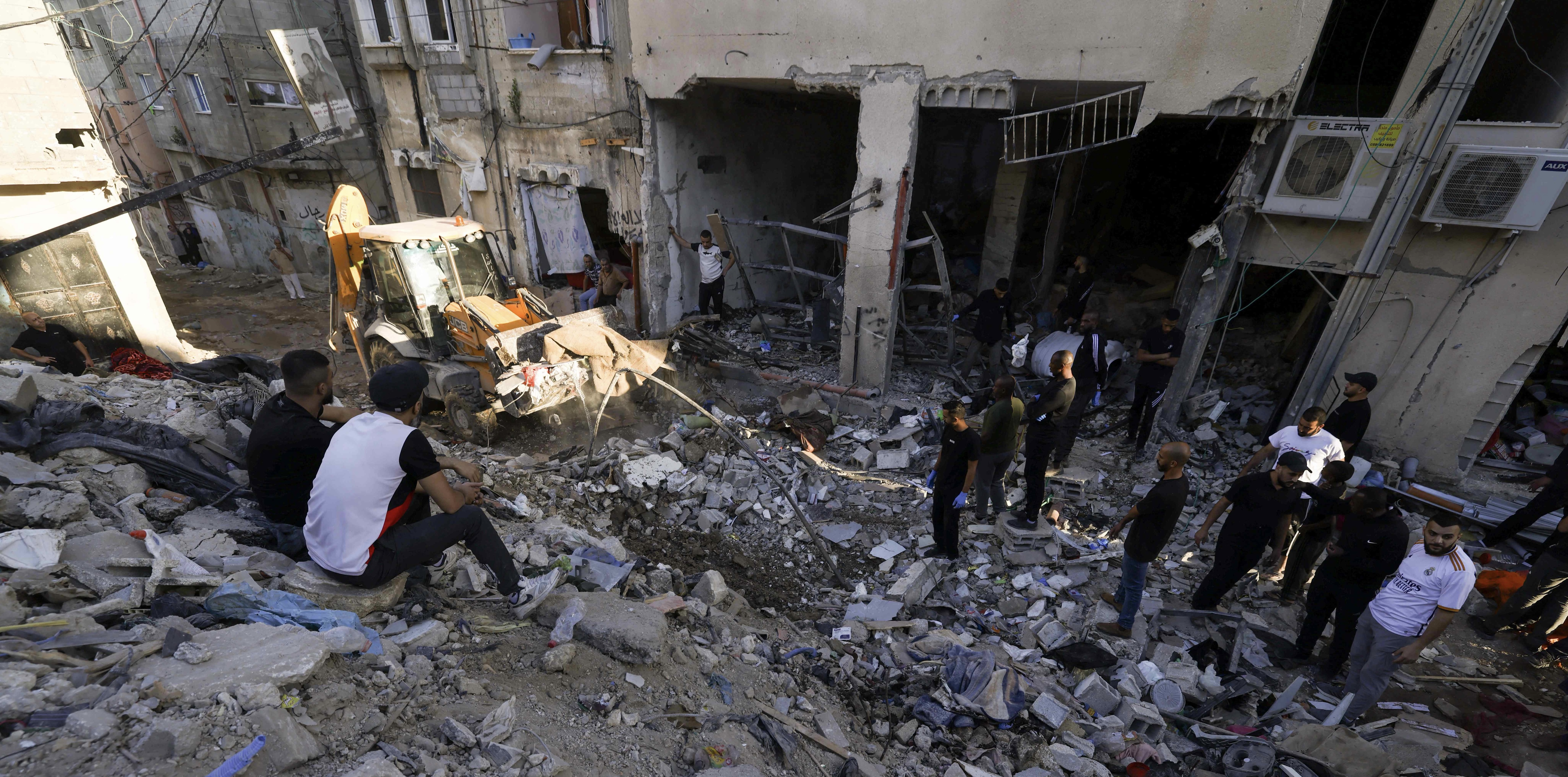 Palestinians inspect the damage at the site of an overnight Israeli airstrike on the Tulkarem refugee camp in the northern occupied West Bank on Friday (AFP photo)