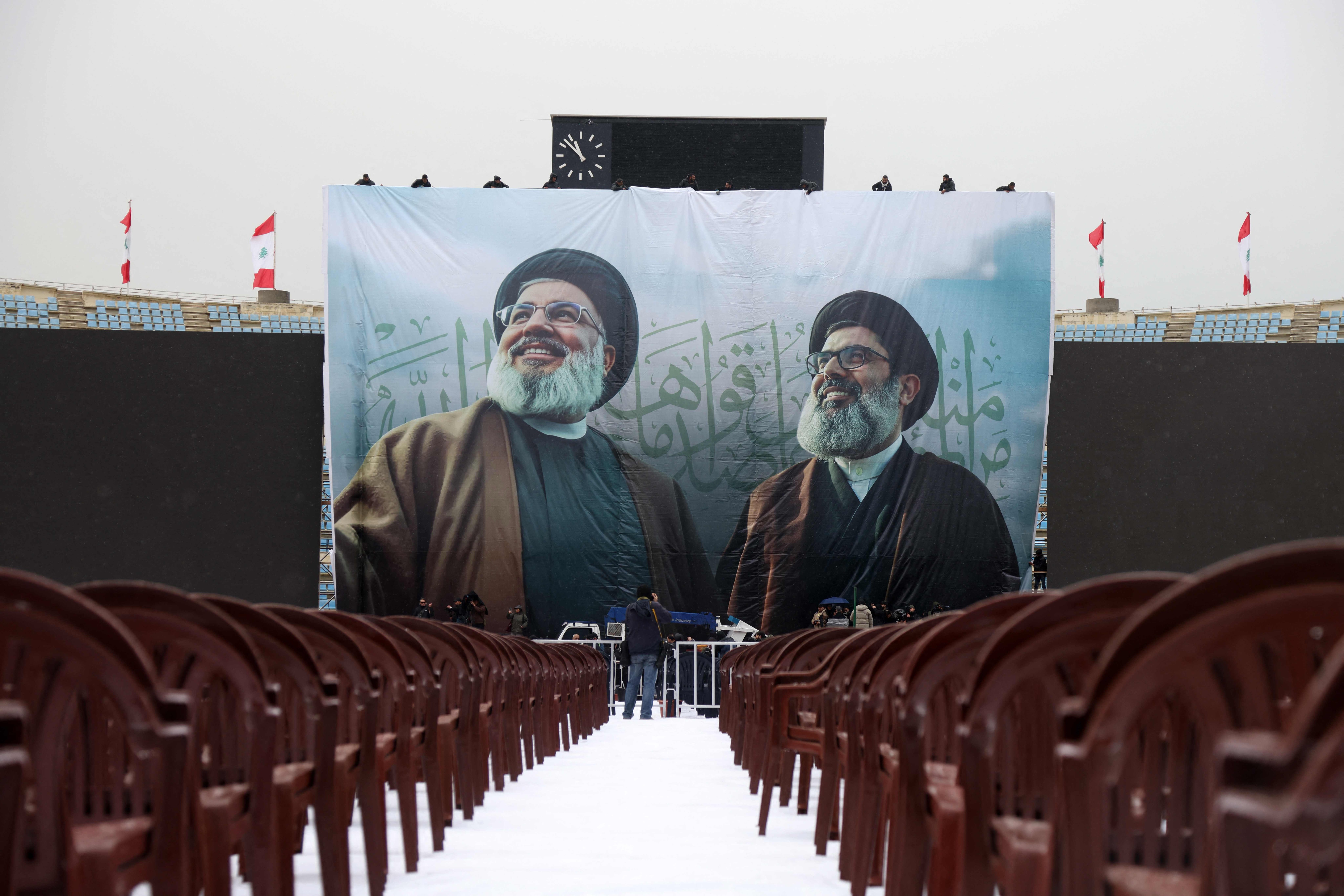 A giant banner bearing the portraits of Hezbollah's slain leader Hassan Nasrallah (L) and Hashem Safieddine, who was chosen to succeed him before he was also killed, hangs in Beirut's Camil Chamoun sports city on February 22, 2025, as preparations take place a day ahead of their funeral ceremony  (AFP photo)