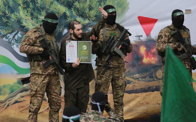 Israeli hostage Eliya Cohen, flanked by Palestinian Hamas fighters, gestures waves after being released along with two others as part of the seventh hostage-prisoner exchange ,in Nuseirat in the central Gaza Strip, on February 22, 2025  (AFP photo)