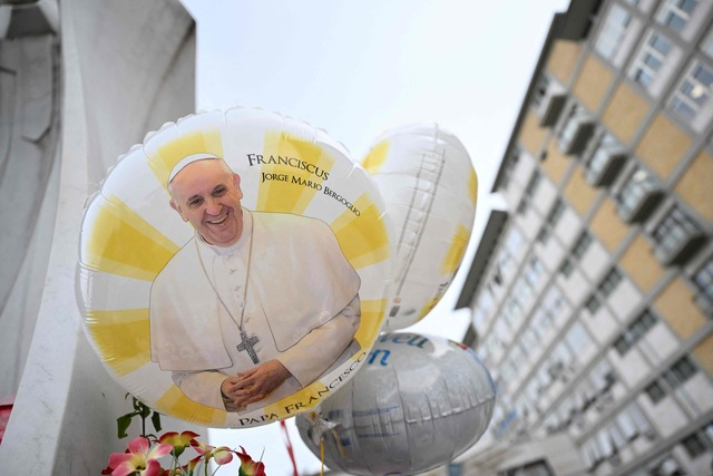 Balloons depicting Pope Francis are laid at the statue of John Paul II outside the Gemelli hospital where Pope Francis is hospitalized, in Rome on February 24, 2025  (AFP photo)