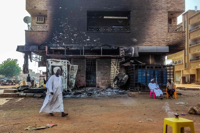 A man walks past a burnt out bank branch in southern Khartoum on May 25, 2023 (AFP photo)