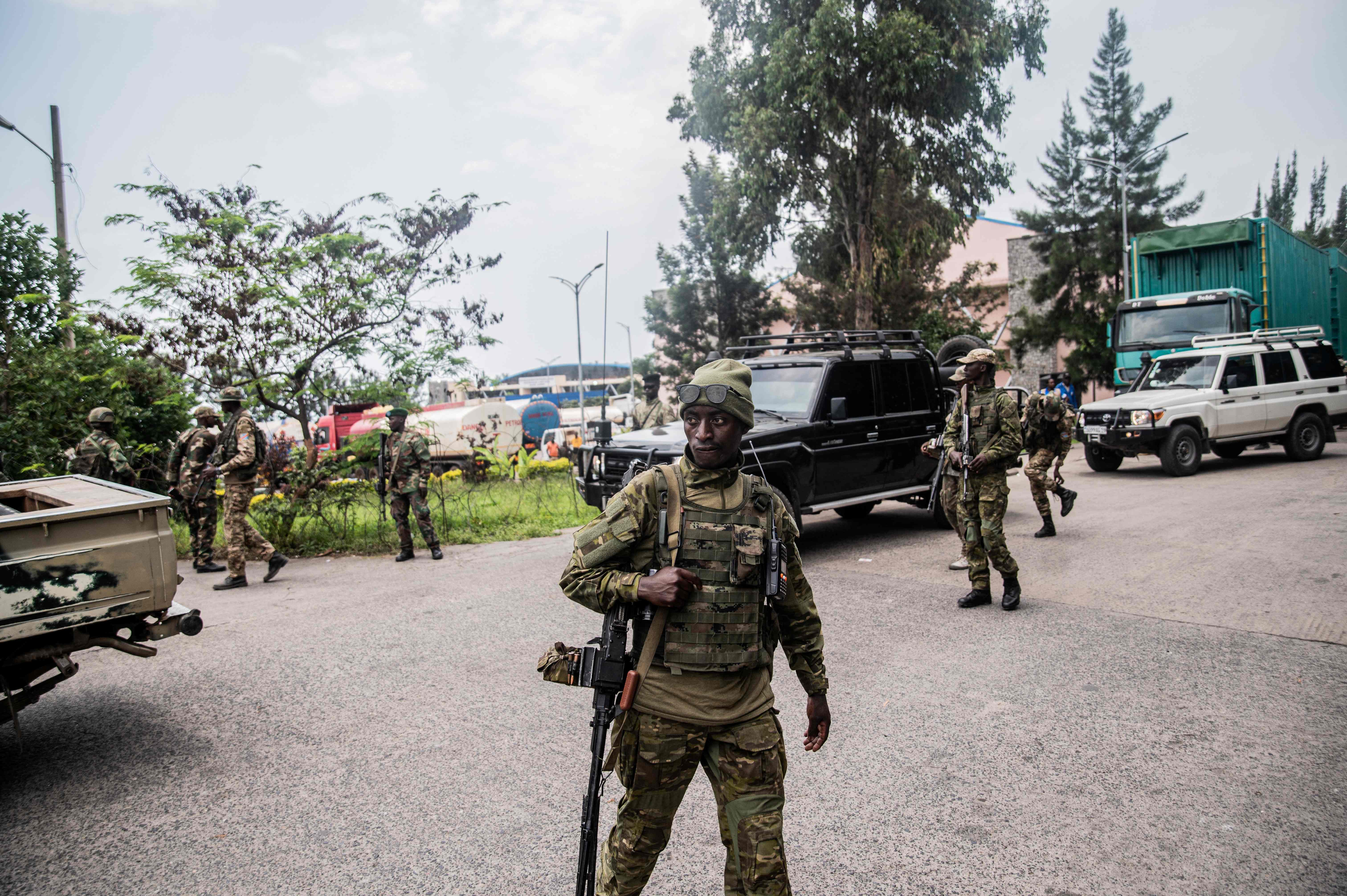 Members of the M23 movement stand guard for the convoy of Democratic Forces for the Liberation of Rwanda  soldiers arriving at the main border crossing between DR Congo and Rwanda in Goma yesterday  during the repatriation of FDLR soldiers by the M23 movement to Rwanda (AFP photo)