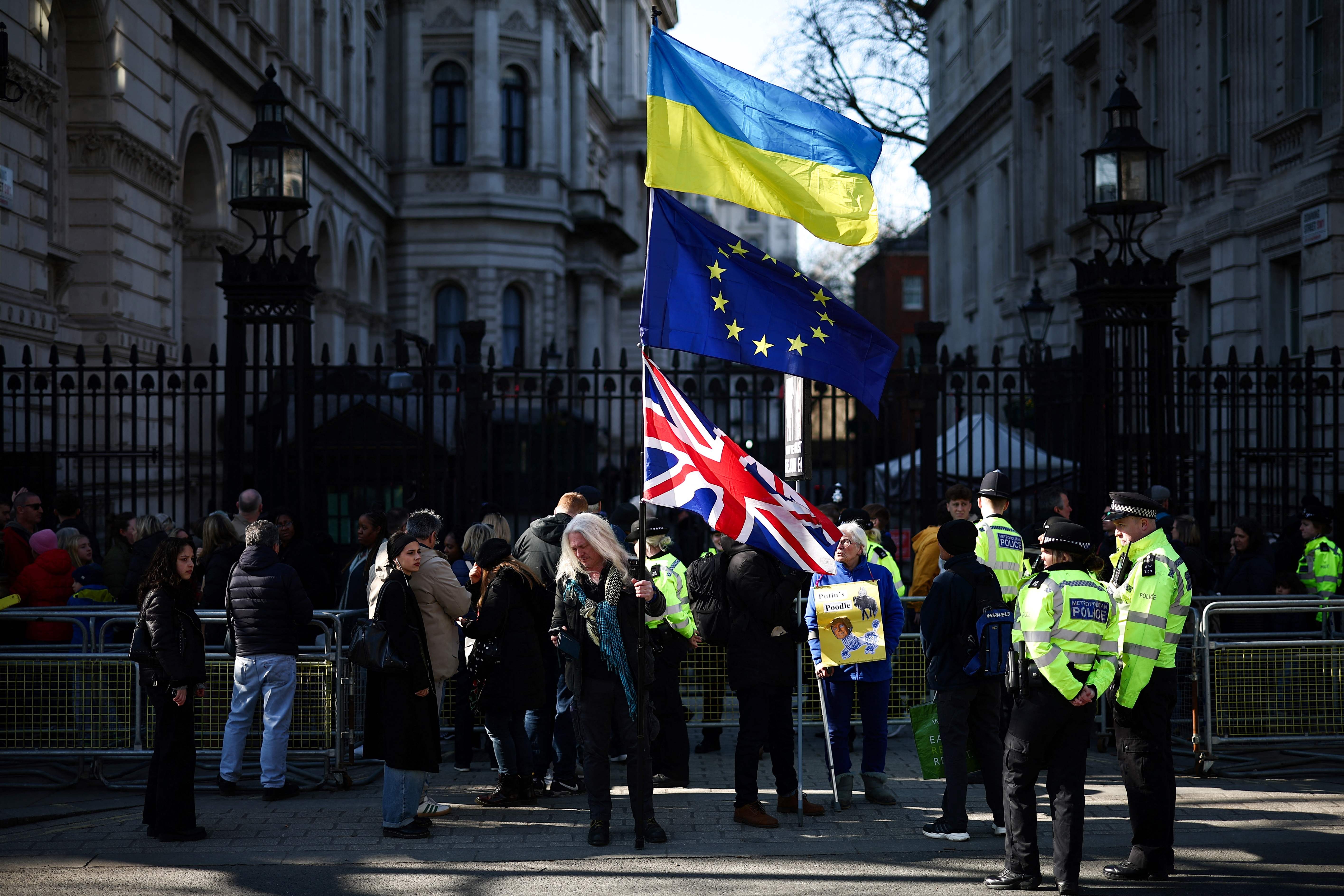 A protestor waves Ukrainian, EU and Union Jack flags during a gathering outside Downing Street, central London, today as European leaders meet for a summit about the war in Ukraine (AFP photo)