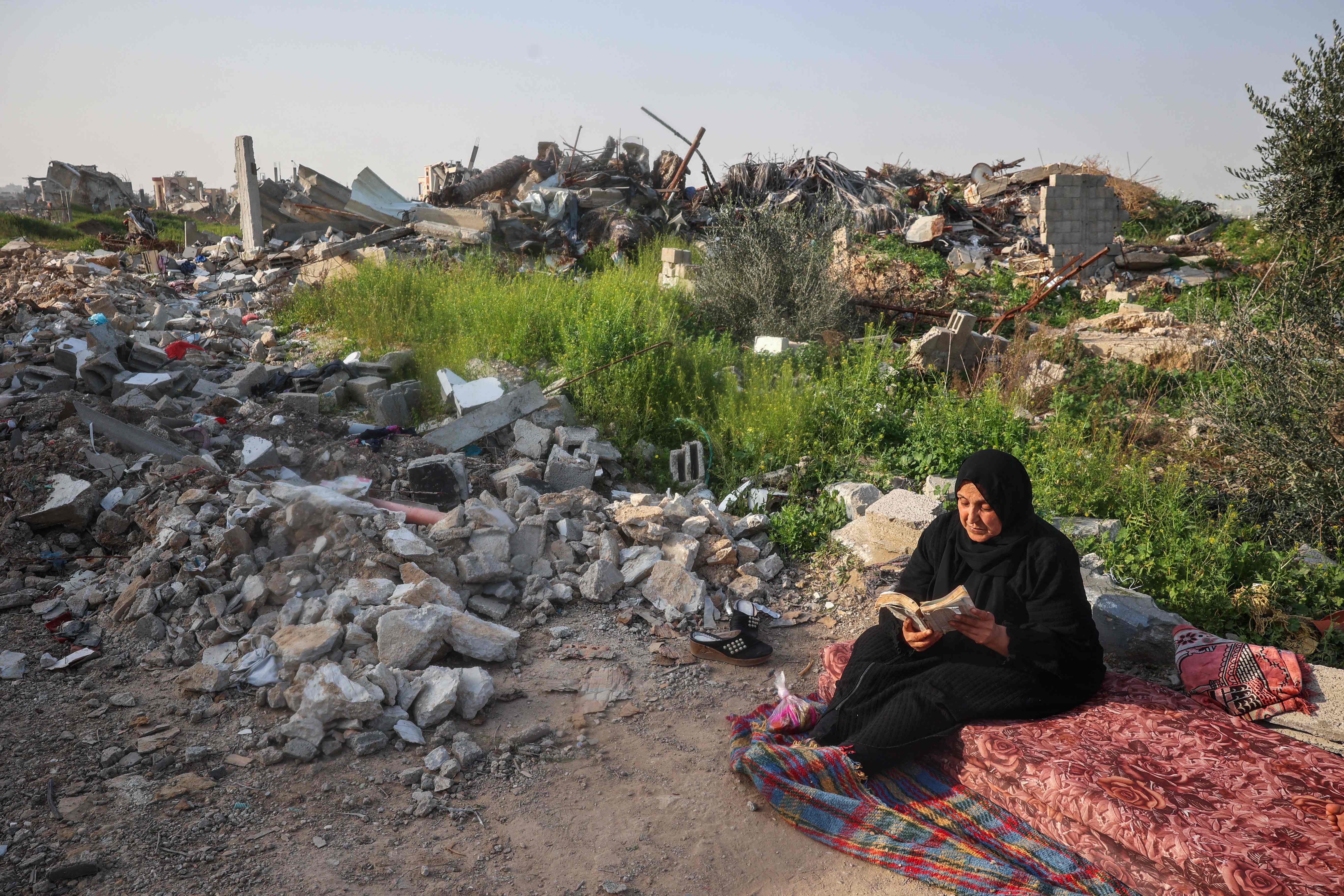 A woman carrying some personal items walks along a devastated street as she leaves the Nur Shams camp for Palestinian refugees, where Israeli forces allowed residents to retrieve belongings after issuing reported demolition notifications for several houses, in the occupied West Bank yesterday (AFP photo)