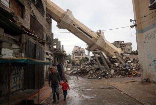 A Palestinian man accompanied by a child walk near a fallen minaret of a destroyed mosque during the Muslim holy fasting month of Ramadan, in the Nuseirat refugee camp in the central Gaza Strip on March 7, 2025 (AFP photo)