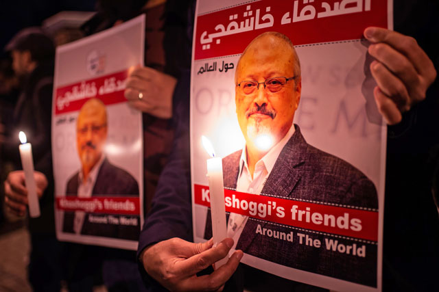 People hold posters picturing Saudi journalist Jamal Khashoggi and lightened candles during a gathering outside the Saudi Arabia consulate in Istanbul on Thursday (AFP photo)