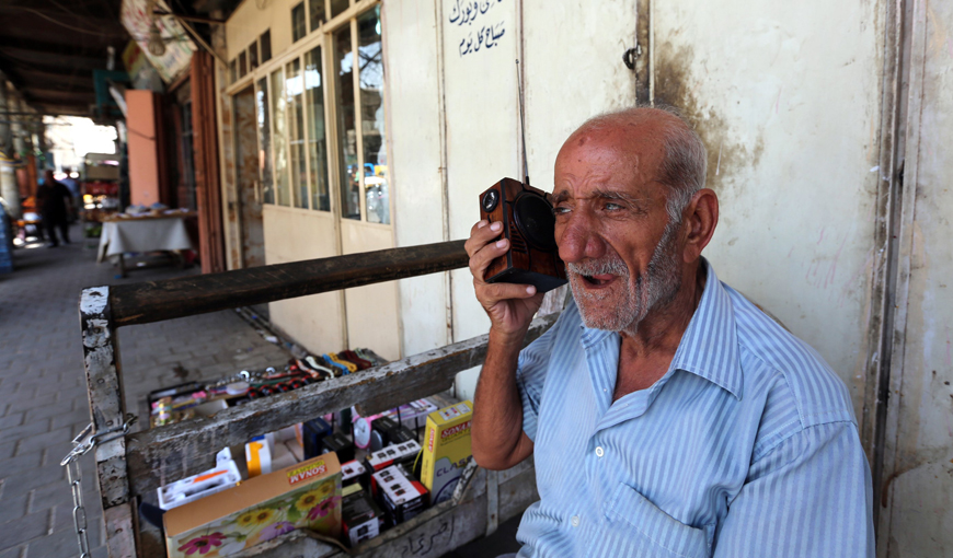 An Iraqi man listens on his portable radio to the speech of  Iraqi Parliament Speaker Salim Al Juburi in downtown Baghdad on Tuesday, as he delivers a statement after parliament unanimously approved Prime Minister Haider Al Abadi’s reform programme aimed at curbing corruption (AFP photo)