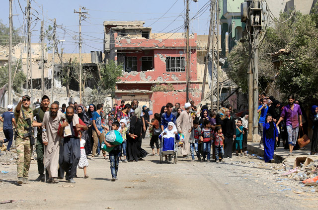Displaced Iraqi people who fled from clashes are pictured in western Mosul, Iraq, on Saturday (Reuters photo)
