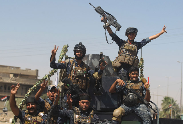 Members of the Iraqi federal police raise the victory gesture as they ride on a humvee while advancing through the Old City of Mosul on Wednesday, as the offensive continues to retake the last district held by Daesh militants (AFP photo)
