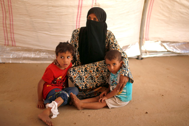 An Iraqi woman who says her husband was a member of Daesh sits with her grandchildren at a tent in the Jada camp south of Mosul, Iraq, August 9 (Reuters photo)