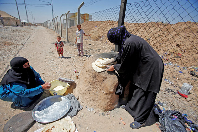 Displaced Iraqi women from Tal Afar make bread in Salamya camp, east of Mosul, Iraq, August 6 (Reuters photo)