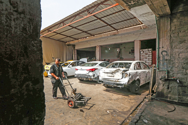 Iraqi mechanics work in a garage in east Mosul on Wednesday, as they repair vehicles that were damaged during the offensive to retake Iraq’s second-largest city from Daesh (AFP photo)