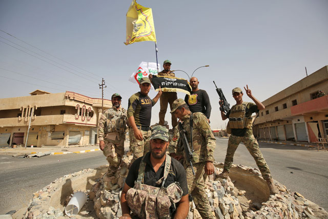 Members of the Iraqi forces, which are backed by fighters from the Hashed Shaabi (Popular Mobilisation Units), pose for a photo in Hawija on Thursday, after retaking the city from Daesh group fighters (AFP photo)