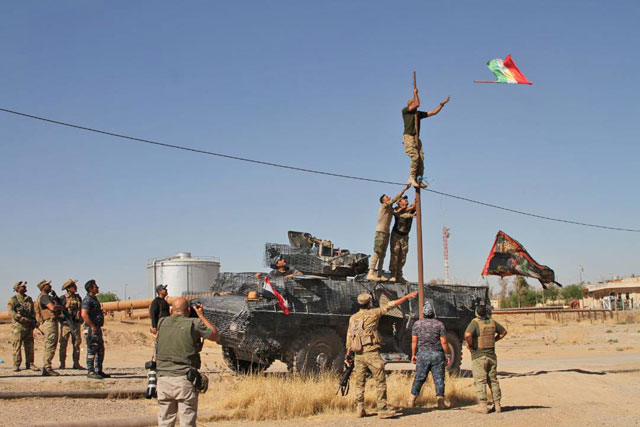 Iraqi forces remove the Iraqi Kurdish Regional flags from the Bai Hassan oil facility after peshmerga forces withdrew from the area in Kirkuk, Iraq, on Tuesday (Anadolu Agency photo)