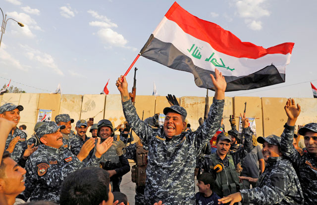 A member of Iraqi federal police waves an Iraqi flag as they celebrate victory of military operations against the Daesh militants in West Mosul, Iraq, on July 2 (Reuters file photo)